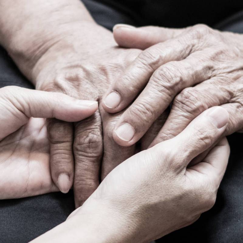 Caregiver, carer hand holding elder hand in hospice care background. Philanthropy kindness to disabled old people concept.Happy mother's day.